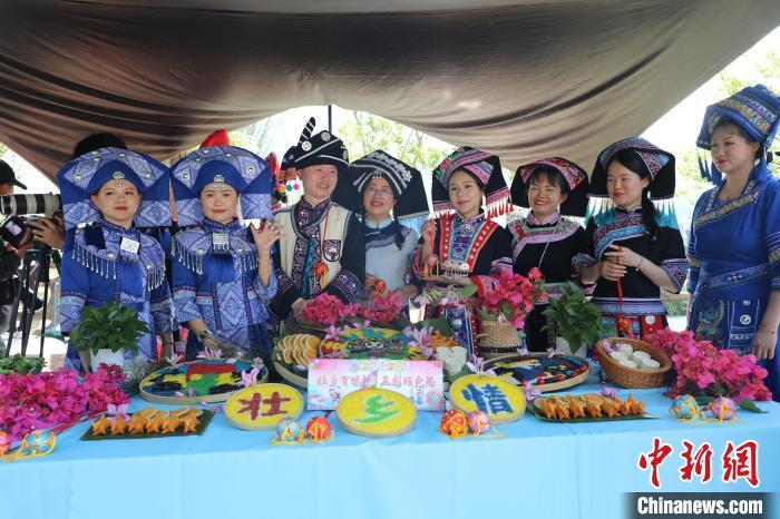 中国侨网4月12日，2025年中越边民“三月三”非遗展示活动在广西靖西市鹅泉景区举行。活动以“绣球传情·奥黛同心”为主题，通过丰富多彩的文化互动与文艺展演，为中越两国青年搭建文化交流的桥梁。图为靖西民众展示五色糯米饭。谢徽 摄　